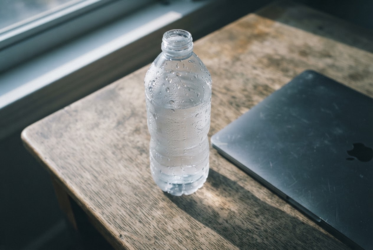 A plastic bottle on a sunlit desk